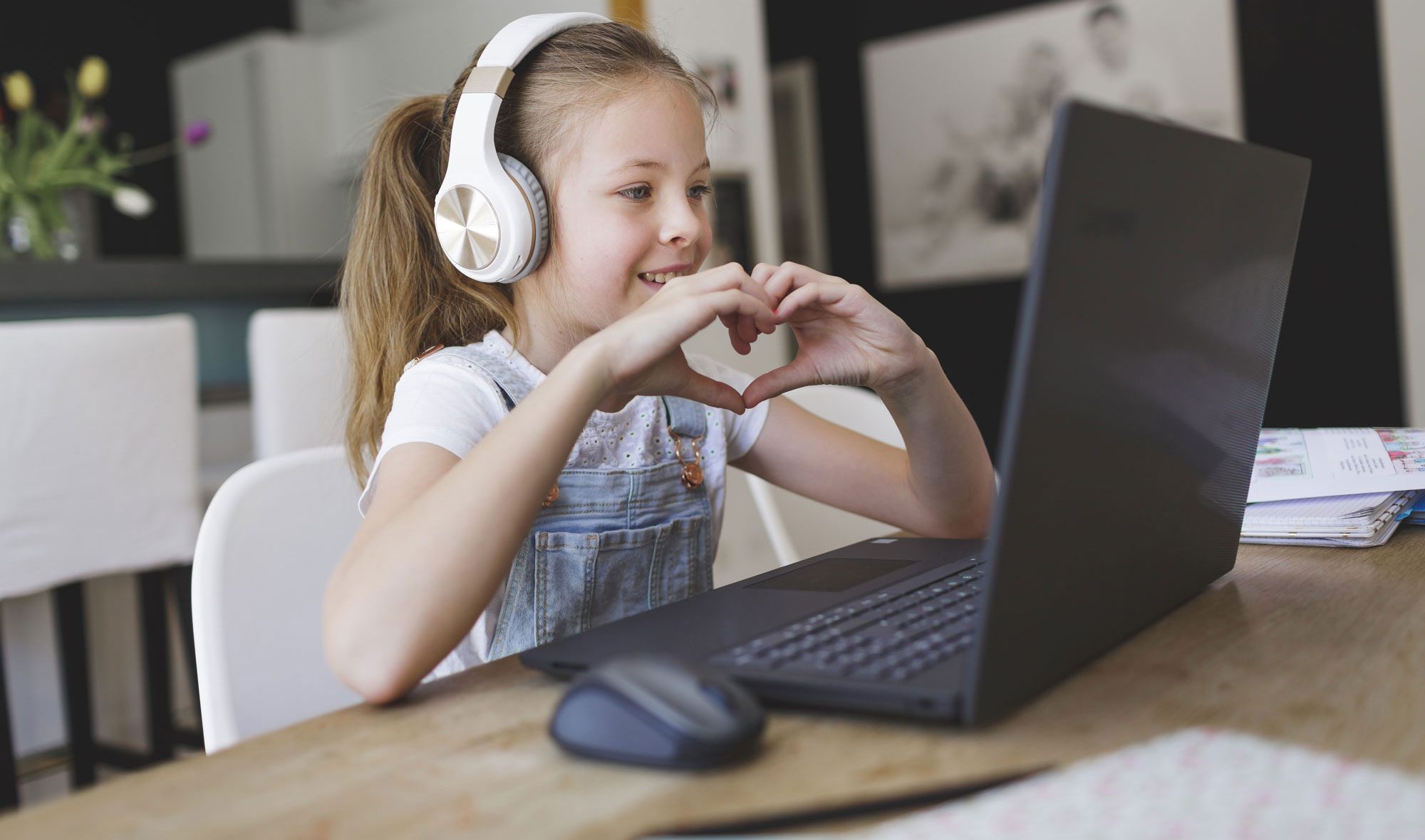 young girl wearing headphones attending online school. about our school